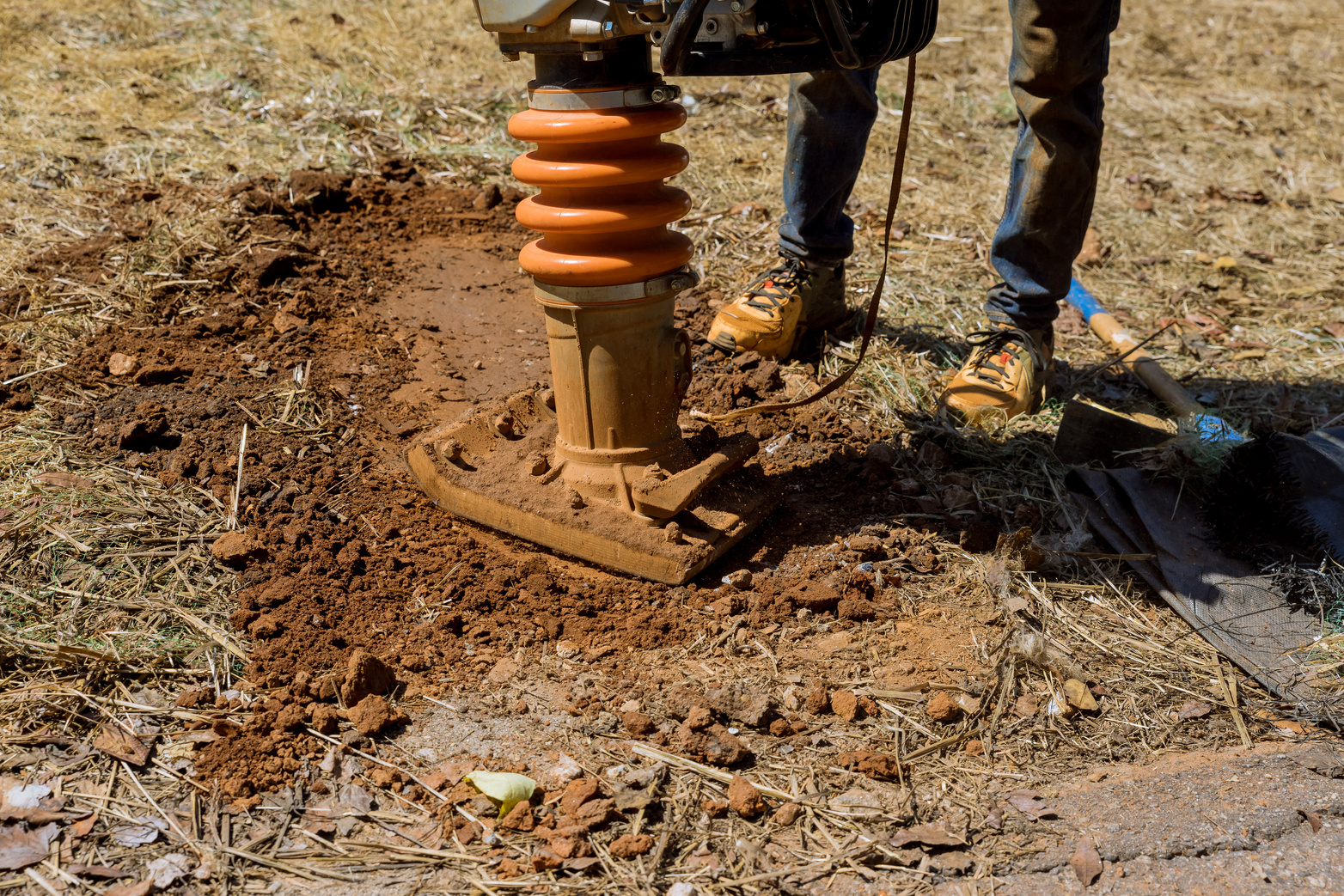 Vibratory plate of Tamping machine compactor tool jumps from tamping machine compactor tool when compacting to ground in a construction site